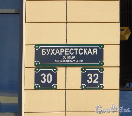 Бухарестская ул., дом 30. Табличка с номерами домов 30 и 32 по Бухарестской улице на фасаде ТРЦ «Континент на Бухарестской». Фото 29 сентября 2014 года.