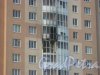 Ул. Маршала Захарова., дом 14, корпус 2. Фрагмент фасада и вид на балкон после пожара из Южно-Приморского парка. Фото 27 мая 2015 г.